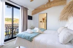 um quarto com uma grande cama branca e uma varanda em Biarritz Surf Lodge Chambre d'hôtes em Biarritz