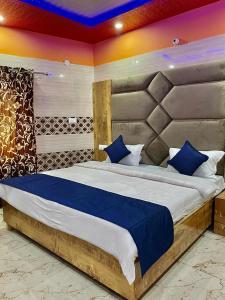 a bedroom with a large bed with blue pillows at Hotel Chandigarh inn in Chandīgarh