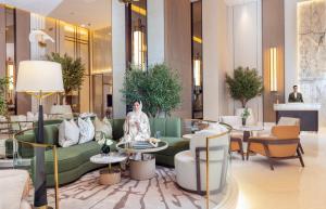 une femme assise sur un canapé dans le hall de l'hôtel dans l'établissement Onyx Arjaan by Rotana, à Manama