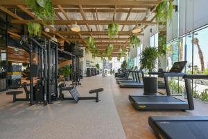 a gym with rows of tread machines and plants at Onyx Arjaan by Rotana in Manama