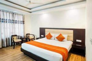 a hotel room with a bed with an orange blanket at Hotel Chandigarh inn in Chandīgarh