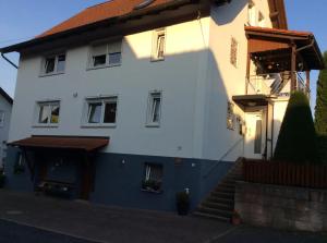 Wildflecken的住宿－Ferienwohnung Ziegler，白色的房子,前面有楼梯
