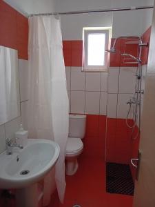 a bathroom with a white toilet and a sink at Villa Sarti in Ksamil