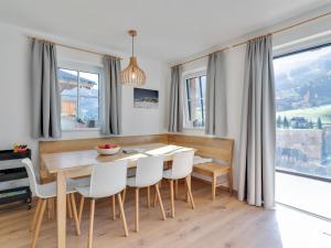 une salle à manger avec une table en bois et des chaises blanches dans l'établissement Modern Chalet in M hlbach am Hochk nig near Ski Area, à Mühlbach am Hochkönig