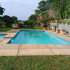 a swimming pool in a yard next to a house at Wylie Hall Guesthouse in Durban