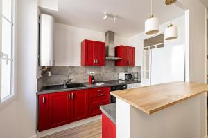 een keuken met rode kasten en een houten aanrecht bij Beautiful T2 in the heart of the suquet - 5min beach and old port in Cannes