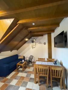 a living room with a blue couch and a table at Wellness Penzion Gabreta in Borová Lada