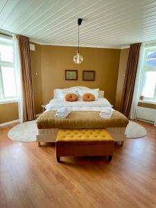 a bedroom with a large bed and two windows at Sentral og fargerik bygårdsleilighet in Halden