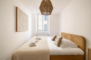 een slaapkamer met een bed met witte lakens en een raam bij Beautiful T2 in the heart of the suquet - 5min beach and old port in Cannes