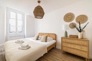 een witte slaapkamer met een bed en een raam bij Beautiful T2 in the heart of the suquet - 5min beach and old port in Cannes