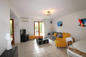 a living room with a couch and a tv at CARBAU Maisonnette pour 8 personnes dans une résidence privée avec piscine à Carqueiranne in Carqueiranne