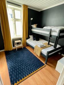 a bedroom with two bunk beds and a rug at Sentral og fargerik bygårdsleilighet in Halden