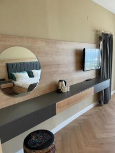 Hotel Carina في كوساداسي: غرفة نوم مع مرآة كبيرة وسرير