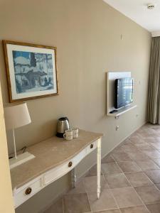 ein Raum mit einem Tisch und einem Fernseher an der Wand in der Unterkunft Hotel Carina in Kusadası