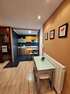 a living room with a table and a kitchen at Apartamento Enol in Cangas de Onís