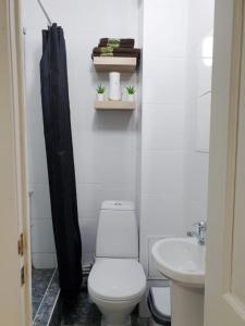 a white bathroom with a toilet and a sink at Милая Студия 2 in Atyrau