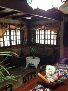 ein Wohnzimmer mit einem Sofa und einem Tisch in der Unterkunft Recanto beira rio - Sao Pedro da serra. in Nova Friburgo