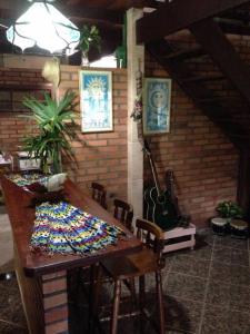 um quarto com uma mesa de madeira com cadeiras e uma parede em Recanto beira rio - Sao Pedro da serra. em Nova Friburgo