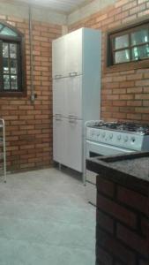 ノバ・フリブルゴにあるRecanto beira rio - Sao Pedro da serra.のキッチン(白い冷蔵庫、コンロ付)