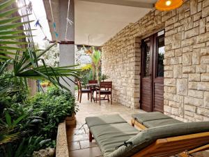 a patio with a table and chairs and a stone wall at Villa Mihaela Porec in Poreč