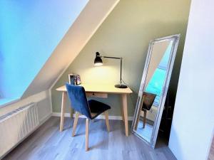 a desk with a mirror and a lamp and a chair at Apartment-Zschachwitz-kleine-Wohlfuehlferienwohnung in Dresden
