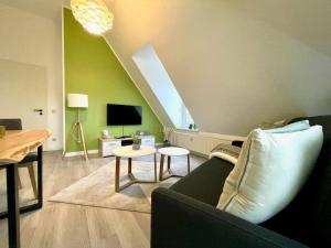 a living room with a couch and a tv at Apartment-Zschachwitz-kleine-Wohlfuehlferienwohnung in Dresden