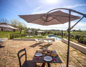 a table with an umbrella on a patio at Borgo Elissa Country Relais in Certaldo +111 photos