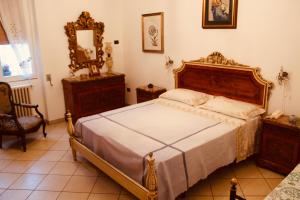 - une chambre avec un lit, un miroir et une chaise dans l'établissement Maison Luigi - Casa Vacanze1, à Nociglia