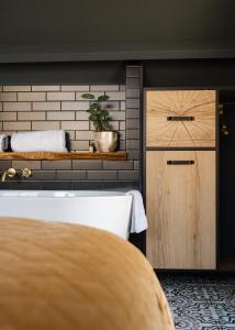 a bedroom with a wooden door and a brick wall at Huisje Hartenlust in Bodegraven