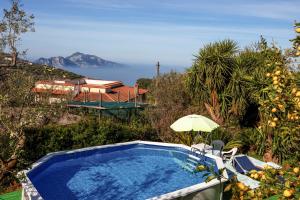 a swimming pool with an umbrella and a view of the ocean at Raggio di Sole in Massa Lubrense