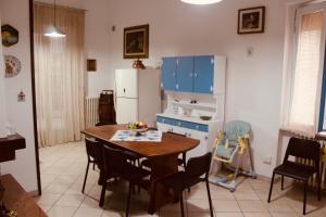 Il comprend une cuisine équipée d'une table en bois et d'un réfrigérateur. dans l'établissement Maison Luigi - Casa Vacanze1, à Nociglia