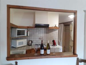 a kitchen with two bottles and two glasses of wine at Le Vendangeur in Chassey-Le-Camp