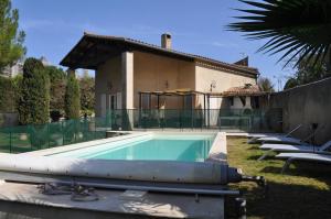 a swimming pool in the yard of a house at Le Charme de l'Orée des Lices in Carcassonne