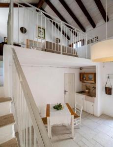uma cozinha e sala de jantar com uma mesa e escadas em Masseria Caretti Grande em Casalabate