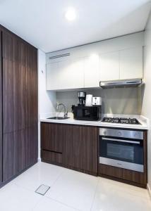 a kitchen with white cabinets and a stove top oven at Goldbest-Reva Burj Khalifa view in Dubai