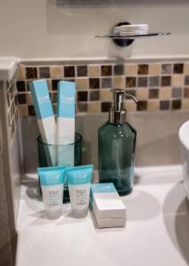 a bathroom counter with a bottle of soap and toothbrushes at Goldbest-Reva Burj Khalifa view in Dubai