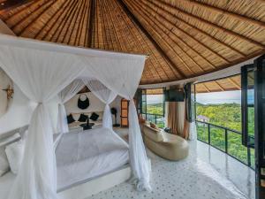 a bedroom with a bed with a canopy at Hillstone Luxury Village in Ungasan