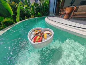 a basket of food in the water in a swimming pool at Hillstone Luxury Village in Ungasan