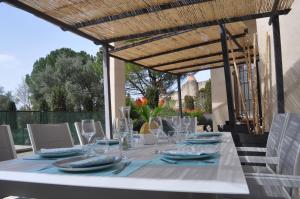 a white table with plates and glasses on a patio at Le Charme de l'Orée des Lices in Carcassonne