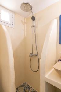 a shower in a bathroom with a sink at Tinos Sunset Villa in Kékhros