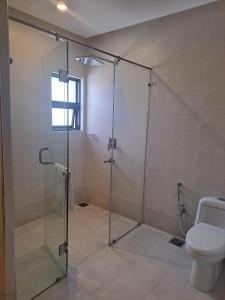 a bathroom with a glass shower with a toilet at Welcome Hotel Islamabad in Islamabad