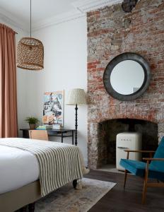 a bedroom with a brick wall with a bed and a mirror at Artist Residence Bristol in Bristol