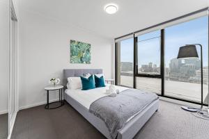 a bedroom with a bed and a large window at Skyline City Zen in Melbourne