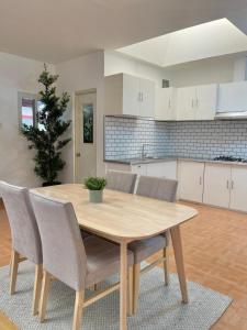 a dining room table with chairs and a kitchen at Qali Home in Olongapo