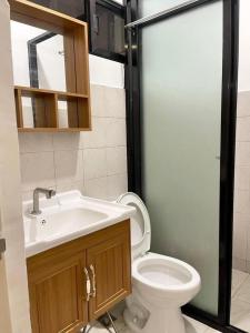 a bathroom with a white toilet and a sink at Qali Home in Olongapo