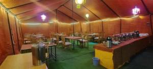 a room with tables and chairs in a restaurant at Blue Waves Camps Lake View Pangong in Tangtse