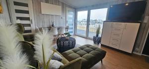 a living room with a couch and a television at Mobilheim Marine Glück im Yachthafen Peenemünde in Peenemünde