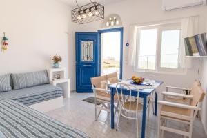 a living room with a table and a blue door at Tinos Sunset Villa in Kékhros