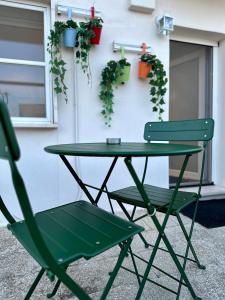 een groene tafel en twee stoelen voor een gebouw bij Residenza 1930 in Matera