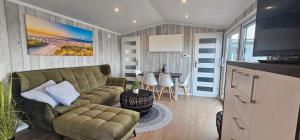 a living room with a couch and a table at Mobilheim Marine Glück im Yachthafen Peenemünde in Peenemünde
